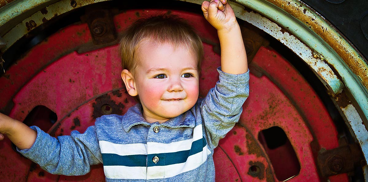 Kid & Family Photography - Peoria, IL - Dave Zumbek Photography Photo of a Happy Child in an old Farm Tractor Tire, Peoria, IL
